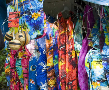 Souvenirstand auf Jamaica mit bunten Kleidern, Mützen und Taschen