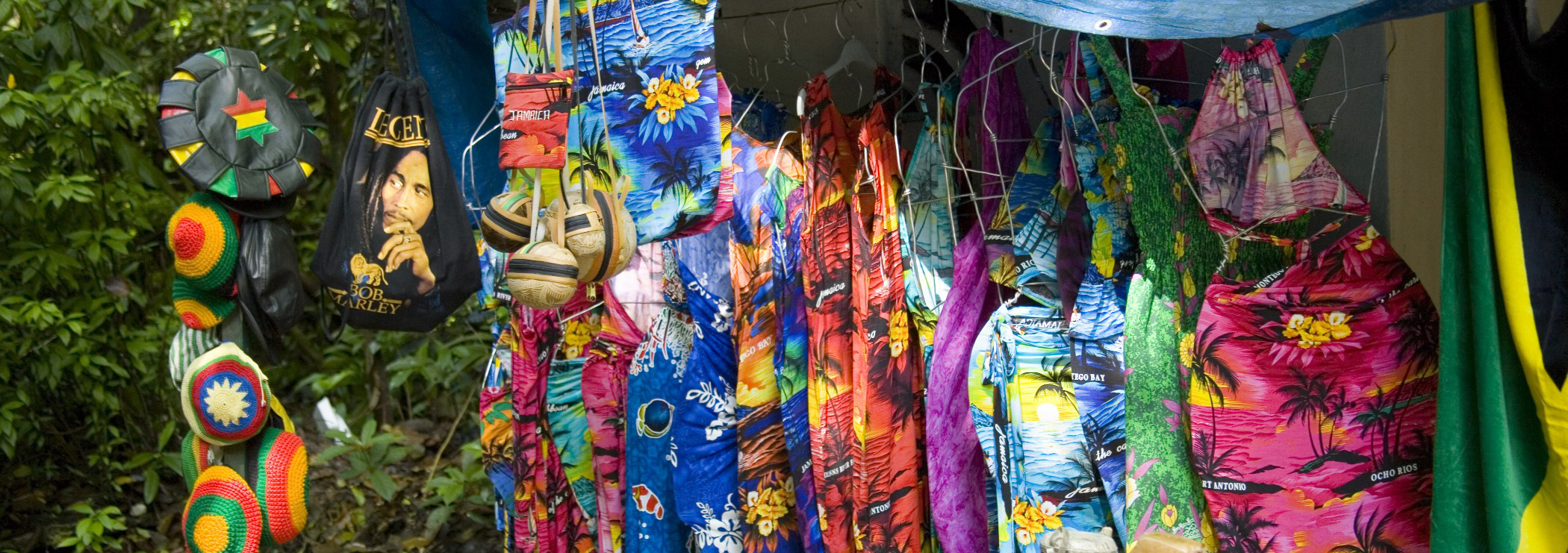 Souvenirstand auf Jamaica mit bunten Kleidern, Mützen und Taschen