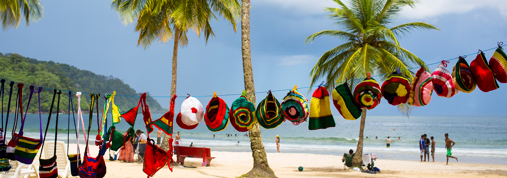 Wäscheleine mit bunten Taschen und Mützen am Strand von Maracas auf Trinidad