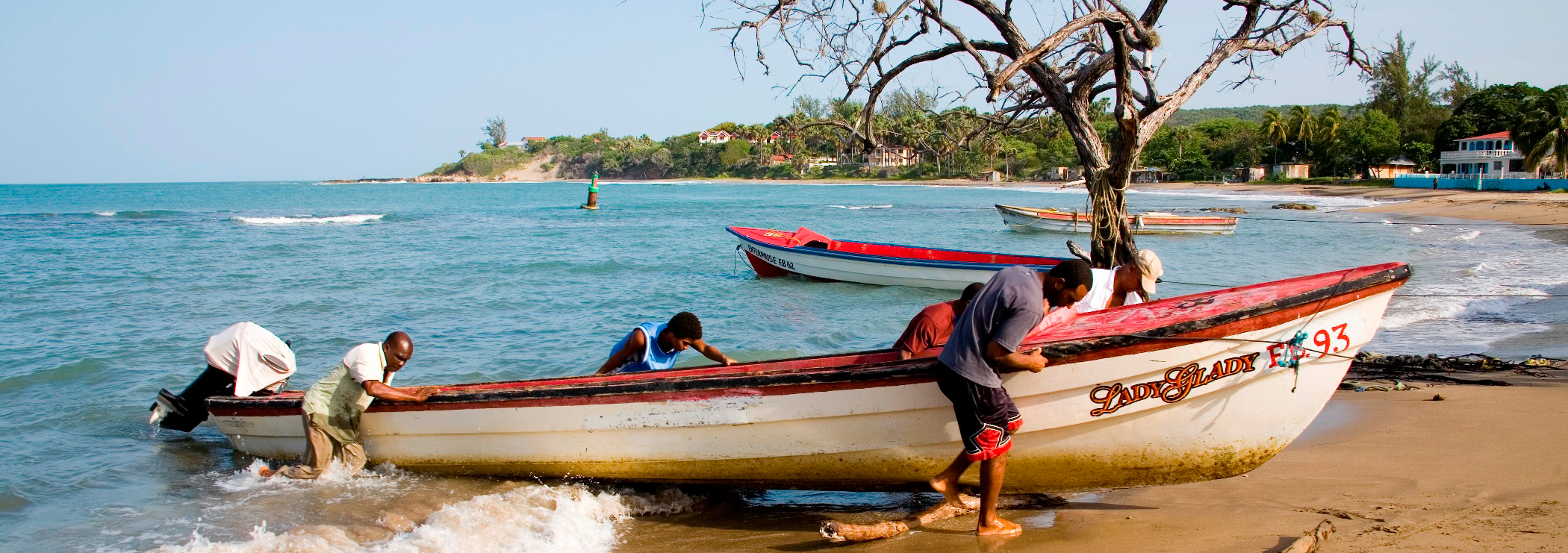 Fischer mit Boot am Strand an Jamaicas Südküste