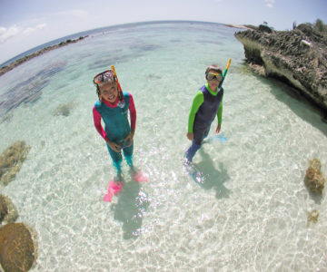 Zwei Kinder mit Schnorchelausrüstung im flachen Wasser auf Bonaire
