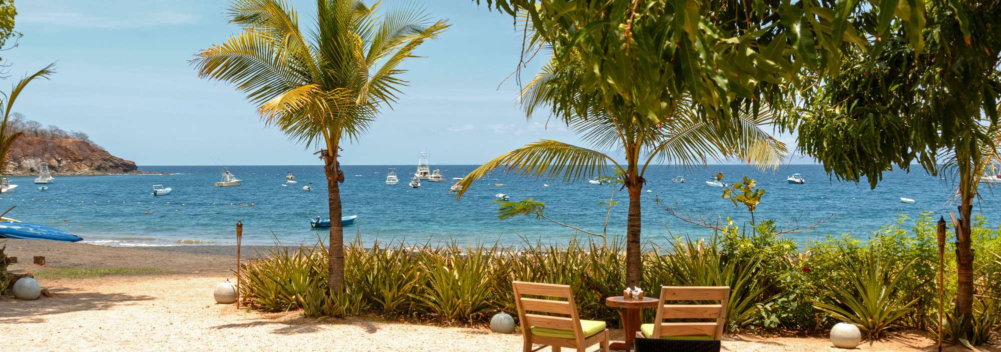 Dunkler Strand in Guanacaste mit ankernden Jachten in Costa Rica