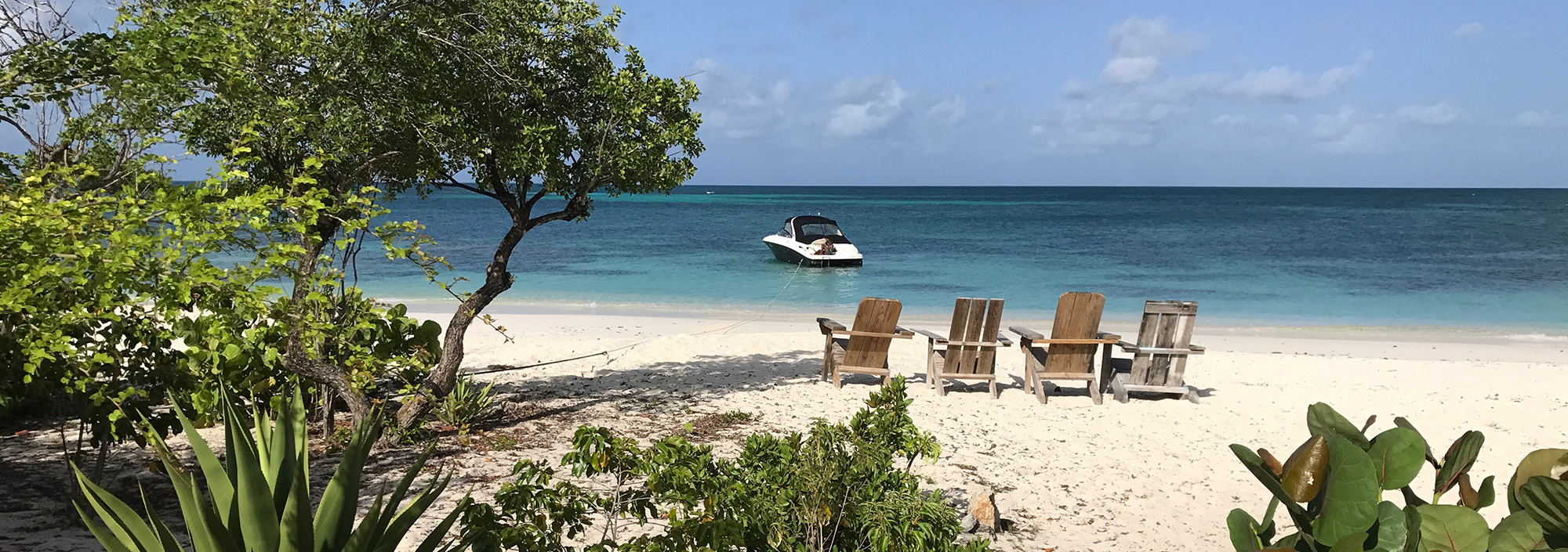 Strand mit ankernder Jacht