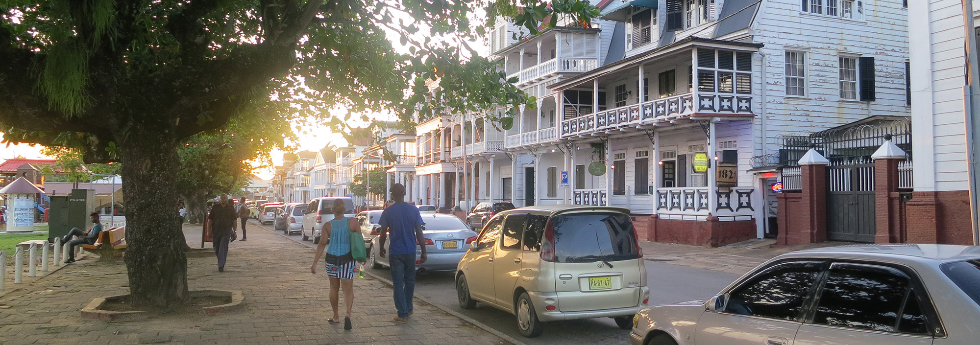 Stadtbummel in Paramaribo an der Uferpromenade mit restaurierten weißen Holzhäusern